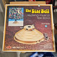Original box with graphic and text describing the Star Bell revolving musical tree stand for indoor use with trees up to 3-3/4" diameter.