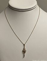 Full view of gold chain with pendant displayed on bust