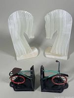 Pair of carved onyx horse head bookends paired with metal bicycle bookends positioned side by side