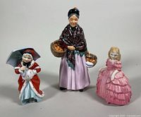 Front view of the three Royal Doulton porcelain figurines together showing size and details.