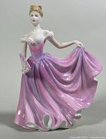 Front view of the porcelain figurine showing detailed pink and purple dress and lace gloves