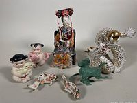 Photo showing all items together: porcelain lady, gilded dragon, bronze horse, children figurines, fish figurines.