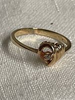 Close-up showing the full ring with 10K gold marked inside the band, heart design with diamond prominently shown.