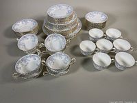 Overview photo showing full set of plates, teacups, saucers, and cream soup bowls arranged on a table.