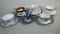 Full set of six assorted porcelain teacups and saucers in different decorative styles and colors