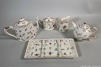 Complete set of porcelain items including coffee pot, serving platter, sugar bowl, creamer, and three-piece teapot set.