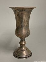 Full profile front view of the Kiddush cup showing its shape and surface etching.
