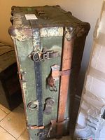 View of the metal and leather strap side with locks and hardware showing corrosion and wear.