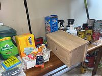 Overview of cleaning supplies and household items including wooden lockable mailbox, dish soap, Swiffer dusters, balloons, and sprays