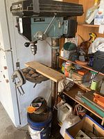 Full view of the assembled drill press with C-clamps on table and vice mounted