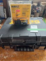 Closed black DeWalt hard plastic carrying case with factory-sealed 14.4V XRP battery pack on top