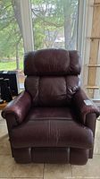 Front view of a burgundy leather recliner showing wear and creases.