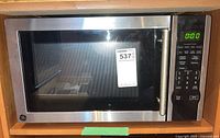Front view of General Electric microwave oven showing size, stainless steel finish, and digital keypad with active display.
