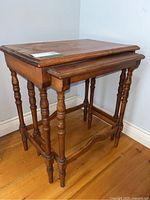 Front angle showing the two vintage wooden nesting tables stacked, turned legs visible