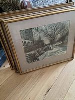 Five framed watercolour prints stacked on the floor showing the size and framing