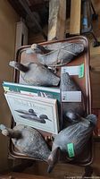 All six wooden decoys and two books arranged on tray