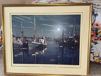 Full view of framed harbor scene print showing fishing boats at dock under cloudy sky