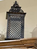 Photo of decorative metal lantern with lattice design, distressed dark finish