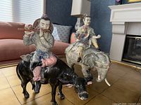 Overall view of both sculptures showing buffalo with flute player and elephant with rider