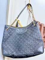 Front view of black quilted leather Tory Burch tote showing diamond pattern and logo