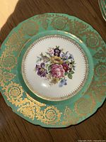 Single turquoise-rimmed Rosenthal Ivory plate with gold filigree and painted floral bouquet center