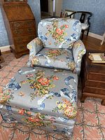 Floral upholstered chair and ottoman with blue floral fabric pattern.