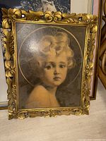 Front view of one framed print showing vintage photo portrait of a young child with curly hair in a gold ornate frame