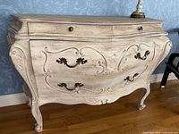 Front view of the painted French Provincial style sideboard showing two small top drawers with round knobs and two larger bottom drawers with decorative metal handles.