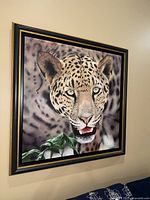 Framed large leopard portrait art showing the full piece hanging on a wall in good lighting.