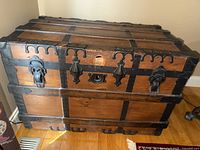 Front and top view of large wooden chest with metal bracket reinforcement and latch locks.