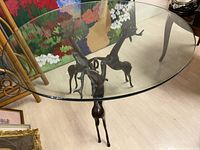 Front perspective view of the round glass top table and metal reindeer base