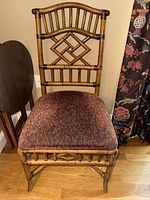 Full view of a single bamboo-style dining chair showing frame and seat upholstery.