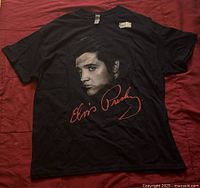 Black Elvis Presley T-shirt with large portrait and red signature on front, size XL, new with tags visible