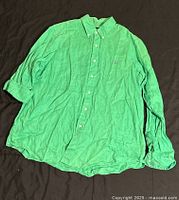 Front view of green Polo XL button-up shirt laid flat showing button-down collar, button placket, long sleeves, and embroidered Polo logo on chest.