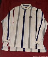 Ralph Lauren long-sleeve button-up shirt laid flat showing vertical stripes in navy, gray, and maroon on white background, buttons and collar visible.