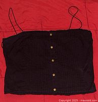 Black Club Monaco women's spaghetti strap top with front buttons shown fully, fabric texture visible.