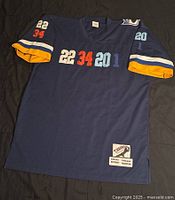 Full front view of navy blue vintage throwback sports jersey with multicolor number patches and bottom label patch.