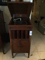 Front view of open lid showing tonearm and turntable inside oak cabinet