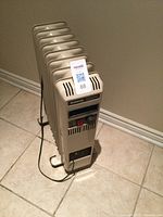 Front quarter view of the electric oil-filled radiator heater showing fins, control panel and power cord.