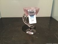 Front angle view of the pink swirled handcrafted glass cup with twisted stem and round base