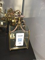 Side view of one brass ceiling light fixture with glass panels, showing chain and mounting plate