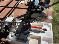 Overview of the King Canada sliding compound mitre saw with visible power cord and blade guard, placed in white Styrofoam.