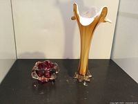 Photo of vintage Murano glass trumpet vase and smaller ruffled ashtray placed on black surface