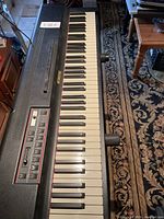 Top-down angle photo showing entire keyboard with 61 keys on an ornate patterned carpet.