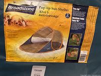 Label showing Broadstone Pop-up Sun Shelter with features including easy setup and fiberglass poles