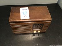 Full view of the vintage wood-cased RCA Victor tube radio showing the top and front with slat speaker grill and control knobs.