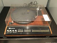 Front view showing platter, tonearm, control panel and dust cover