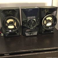 Front view of the Sony stereo system including the main unit and two speakers on either side.