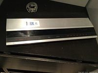 Angled top-front view of unit showing aluminum top panel and black vented chassis