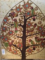 Photo of framed hand painted Tree of Life on fabric artwork showing large stylized tree with colorful birds and flowers on a beige background.